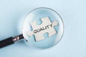 the word quality on puzzle piece with magnifying glass